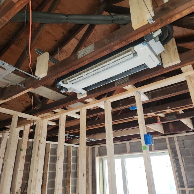 Concealed-duct mini-split air handler mounted in open framing during a renovation