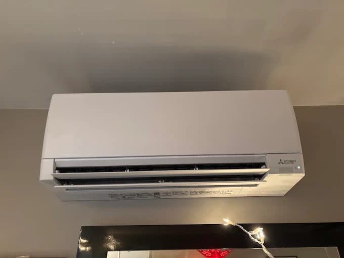Mitsubishi ductless mini-split indoor unit mounted high on a living room wall by KelAire HVAC