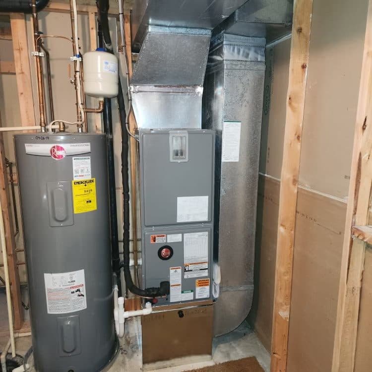 Rheem water heater and air handler installed side by side in a framed utility area