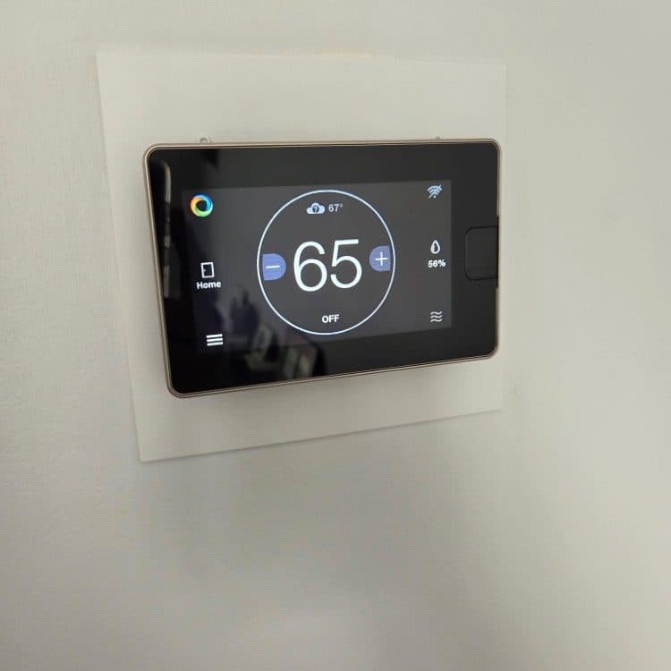 Smart thermostat with humidity display installed on a clean wall plate